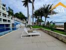 Poolside view with lounge chairs and palm trees near a modern building