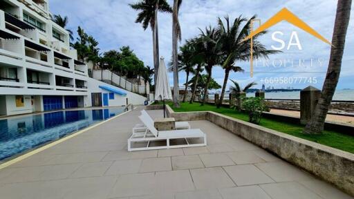 Poolside view with lounge chairs and palm trees near a modern building