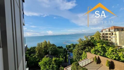 View of a coastal property with a balcony and ocean view