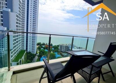 Spacious balcony with outdoor seating and panoramic city and sea view