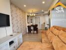 Living room with TV, brown sectional sofa, and dining area