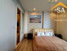 Bedroom with accent wall, artwork, and a double bed with floral pillows