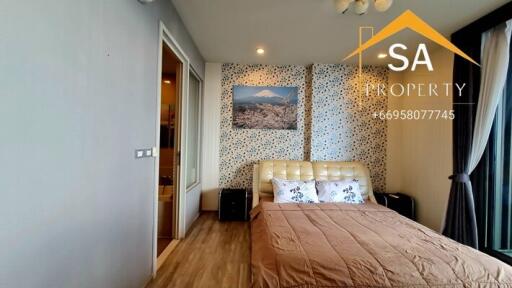 Bedroom with accent wall, artwork, and a double bed with floral pillows