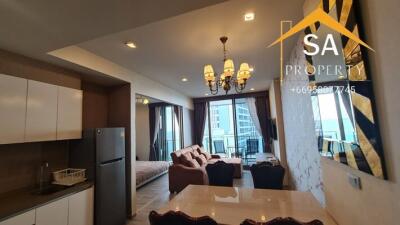 Living room with open kitchen area and balcony view