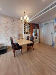 Dining area with wooden flooring, elegant chandelier, and wall art