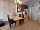 Dining area with wooden flooring, elegant chandelier, and wall art