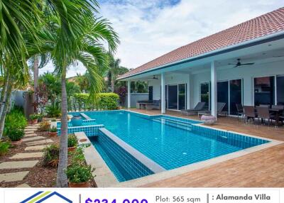 Swimming pool area with adjacent patio and green surroundings