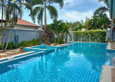 Swimming pool with palm trees and garden area