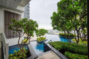 Modern outdoor area with pool and garden overlooking cityscape