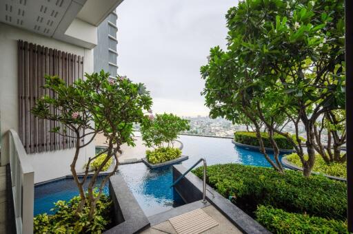 Modern outdoor area with pool and garden overlooking cityscape