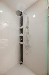 Modern shower area with wall-mounted shower head and built-in shelves