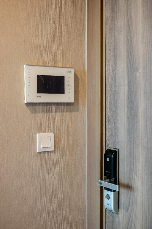 Electronic security system on a wall near a wooden door