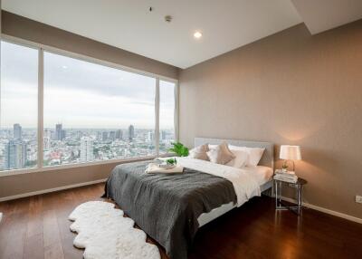 Modern bedroom with large windows offering a city view