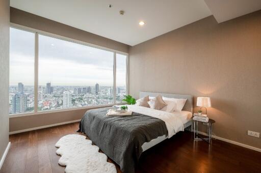 Modern bedroom with large windows offering a city view