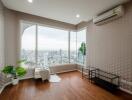 Spacious living room with a large window offering a city view