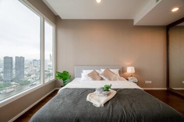 Modern bedroom with large windows and city view