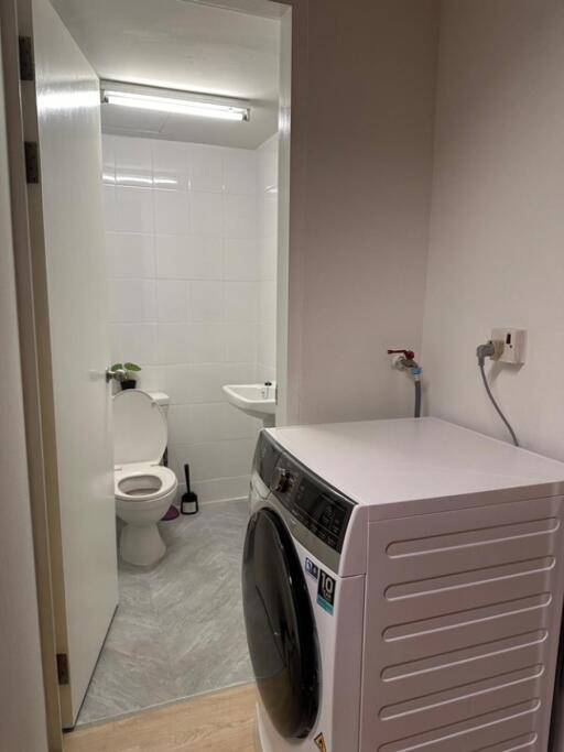 Laundry room with washing machine and adjacent bathroom