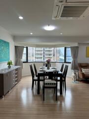 Dining area with a table set for six, large window, and modern furnishings