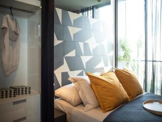 Cozy bedroom with geometric accent wall and balcony