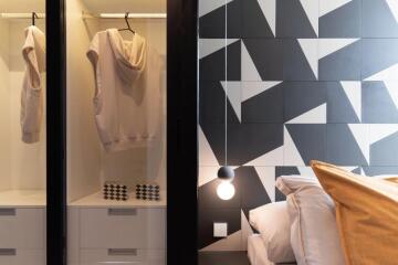 Modern bedroom with geometric wall design and open wardrobe