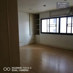 empty bedroom with wooden floor and large window