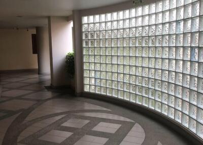 Curved windowed hallway with decorative floor