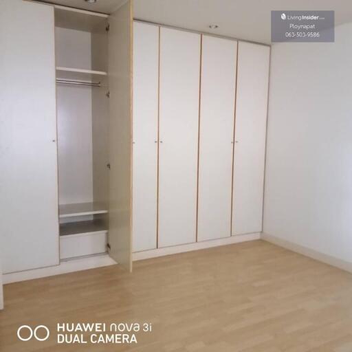 Empty bedroom with built-in wardrobe and wooden floor