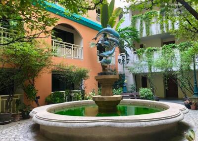 Outdoor courtyard with a fountain and lush greenery in an apartment complex