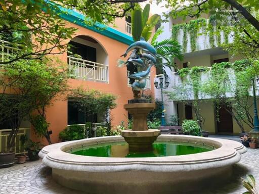 Outdoor courtyard with a fountain and lush greenery in an apartment complex