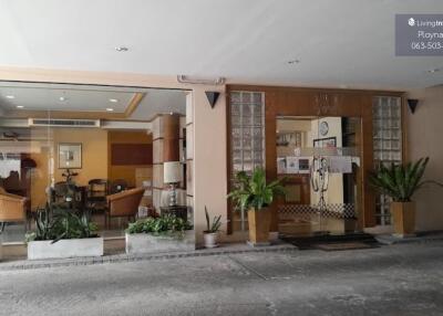 Entrance to a building with a view into a well-furnished lobby