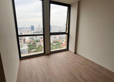 Empty bedroom with large windows and city view