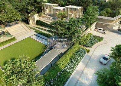 Aerial view of a modern residential building complex with landscaped gardens and driveways.