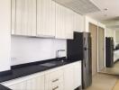 Modern kitchen with white cabinets and black countertop