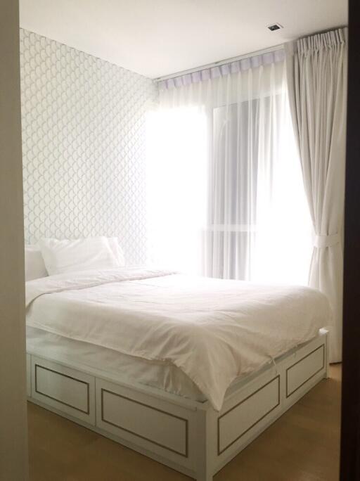 cozy bedroom with natural light and patterned accent wall