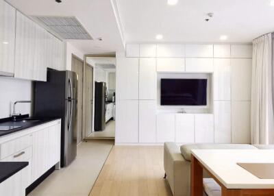 Modern open-plan living area featuring kitchen and living room with wall-mounted TV.