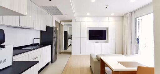 Modern open-plan living area featuring kitchen and living room with wall-mounted TV.