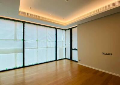 Spacious living room with wooden flooring and large covered windows