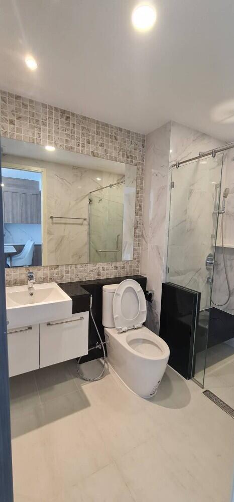 Modern bathroom with a vanity, toilet, and glass-enclosed shower