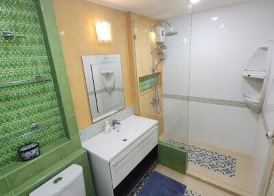 Bathroom with modern amenities and green tile accents