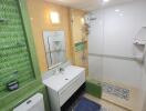 Bathroom with modern amenities and green tile accents