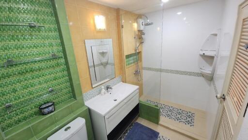 Bathroom with modern amenities and green tile accents