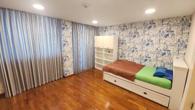 Spacious bedroom with wooden flooring, wardrobe, and bed