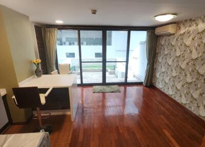 Spacious living room with wooden flooring and balcony access