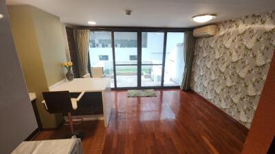 Spacious living room with wooden flooring and balcony access