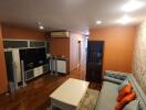 Modern living room with wood flooring, sofa, coffee table, entertainment center, and air conditioning