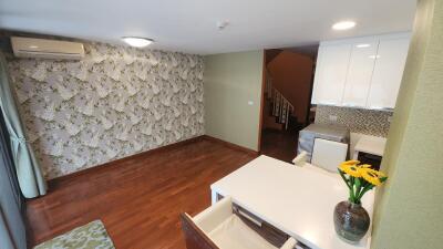 Spacious living room with dining area and floral wallpaper