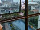 View from window showing cityscape and pool