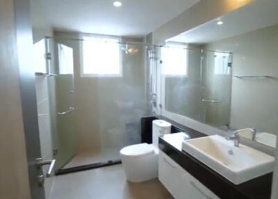 Modern bathroom with glass shower enclosure and large mirror