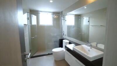 Modern bathroom with glass shower enclosure and large mirror