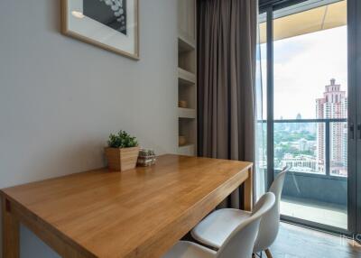 Dining area with a wooden table and chairs next to a large window with a view of the city